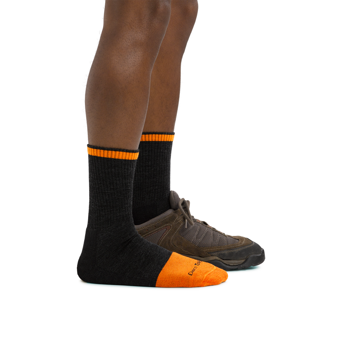 Side view of legs wearing black micro crew socks with orange toe and stripe detail