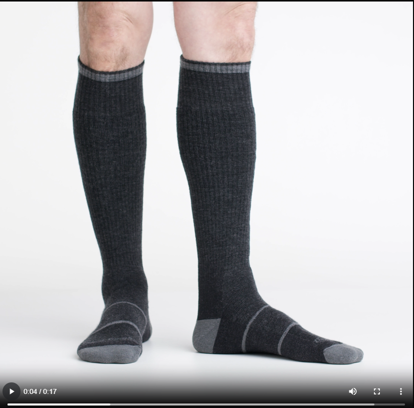 Man wearing dark charcoal knee-high cushioned wool socks with gray accent details