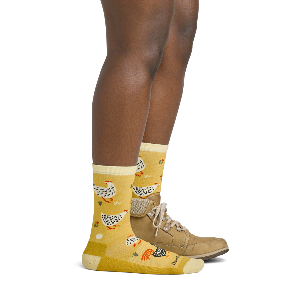 Woman wearing yellow crew socks with chicken pattern paired with tan lace-up shoes