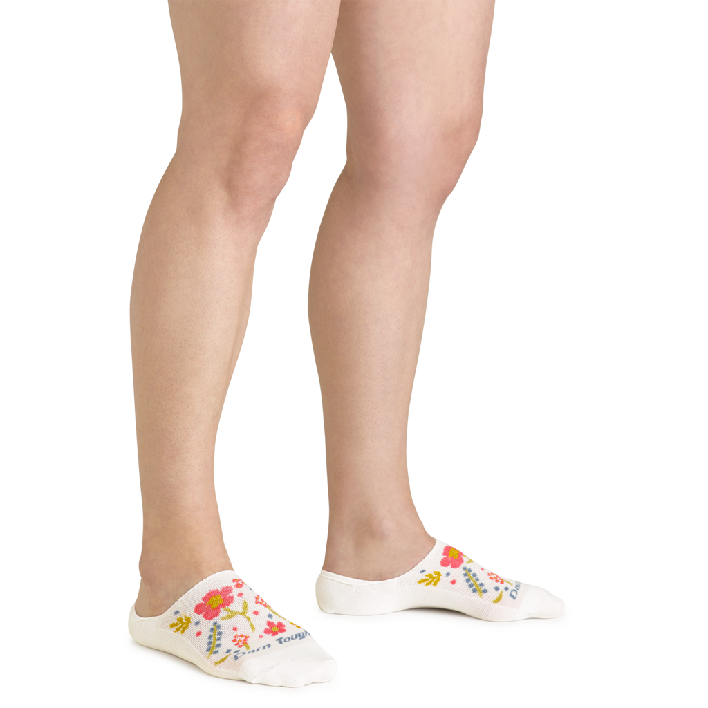 Woman wearing white floral no-show socks with pink and yellow flower pattern on feet