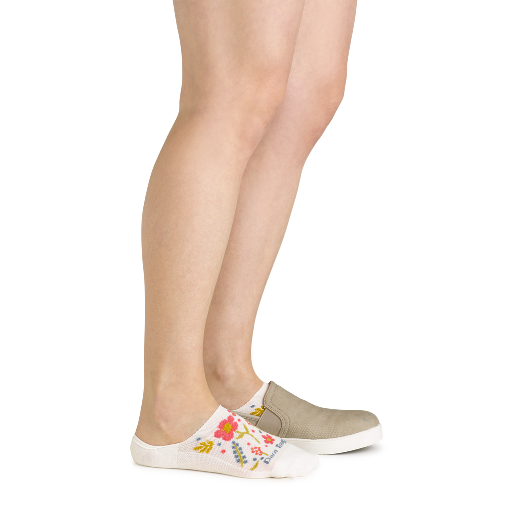 Woman wearing white floral no-show socks with slip-on canvas shoes, side view