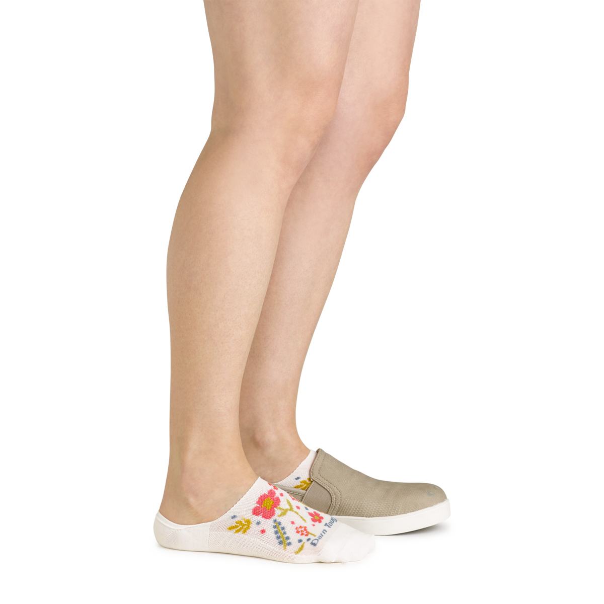 Woman wearing white floral no-show socks with slip-on canvas shoes, side view