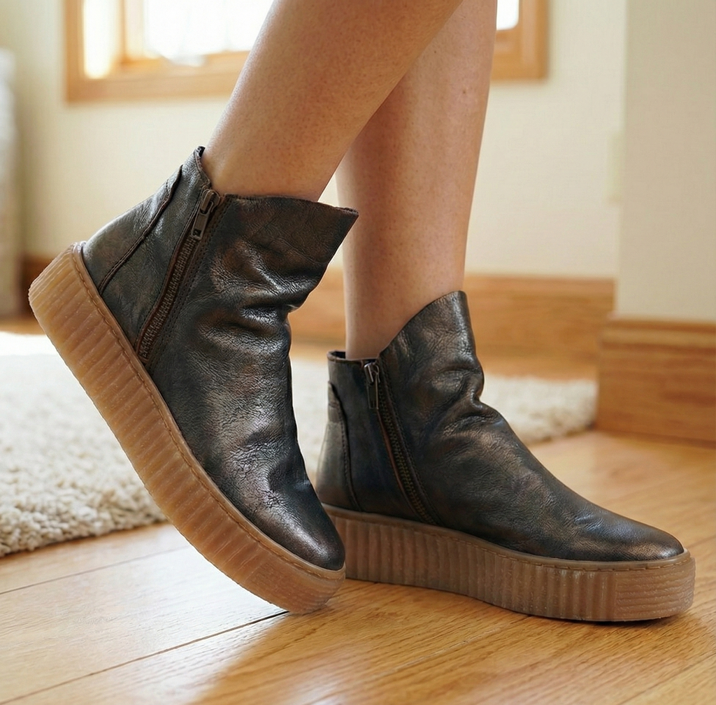 Women wearing dark metallic leather ankle boots with thick creeper platform sole and side zipper