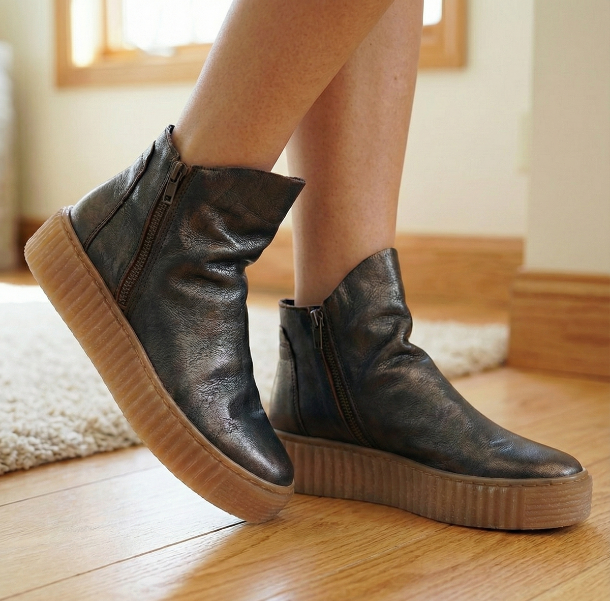 Women wearing dark metallic leather ankle boots with thick creeper platform sole and side zipper
