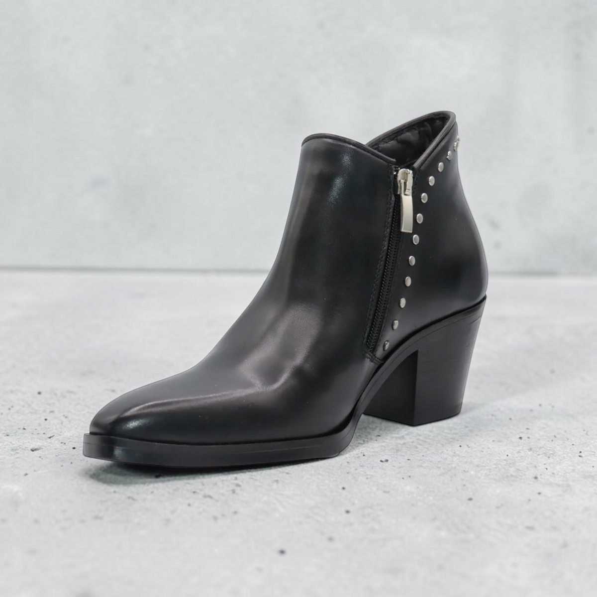 Women's leather ankle boot with pointed toe, block heel, side zipper, and silver stud detail