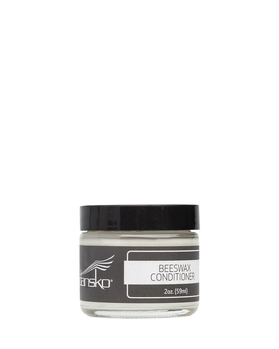 Dansko Beeswax Conditioner in a clear glass jar with black lid, 2oz