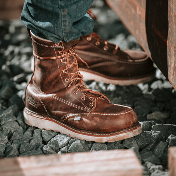 Thorogood men's 8-inch moc toe safety wedge work boots worn on rocky terrain