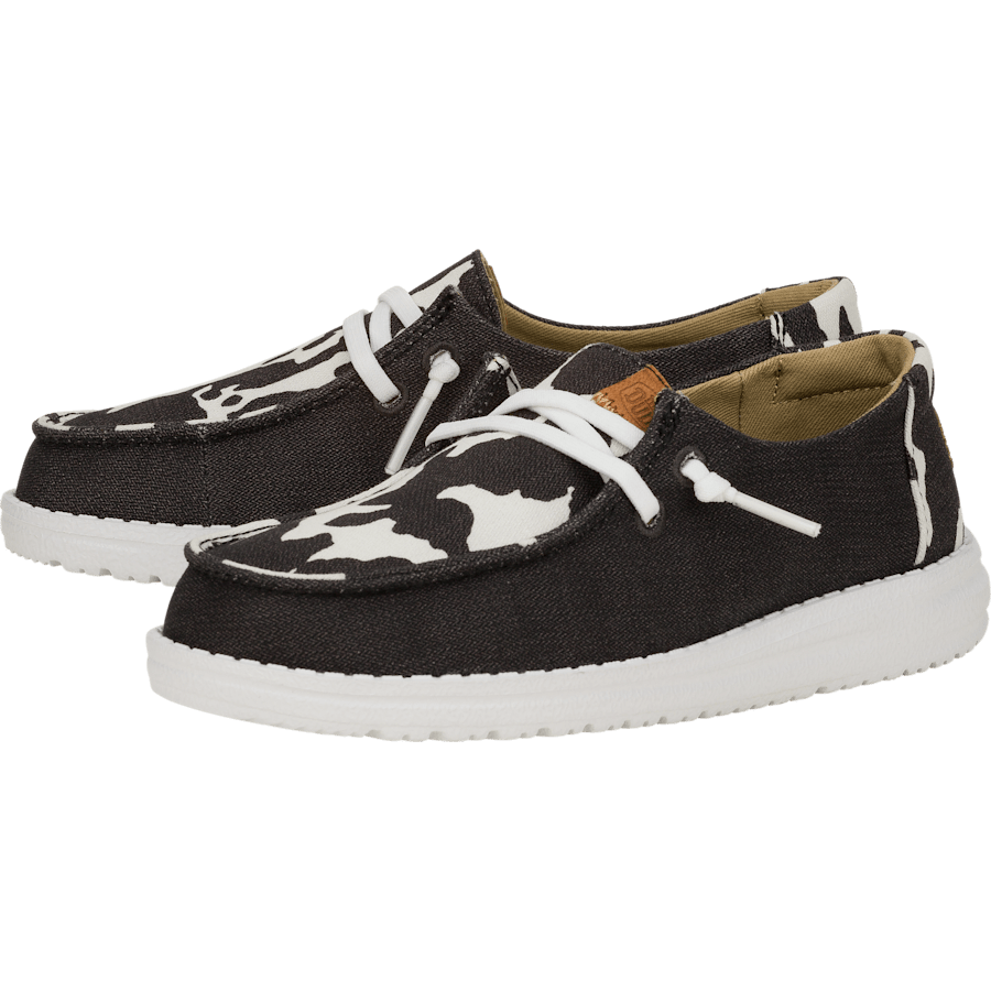 Hey Dude Girls Youth Wendy slip-on shoes with cow print pattern and white sole