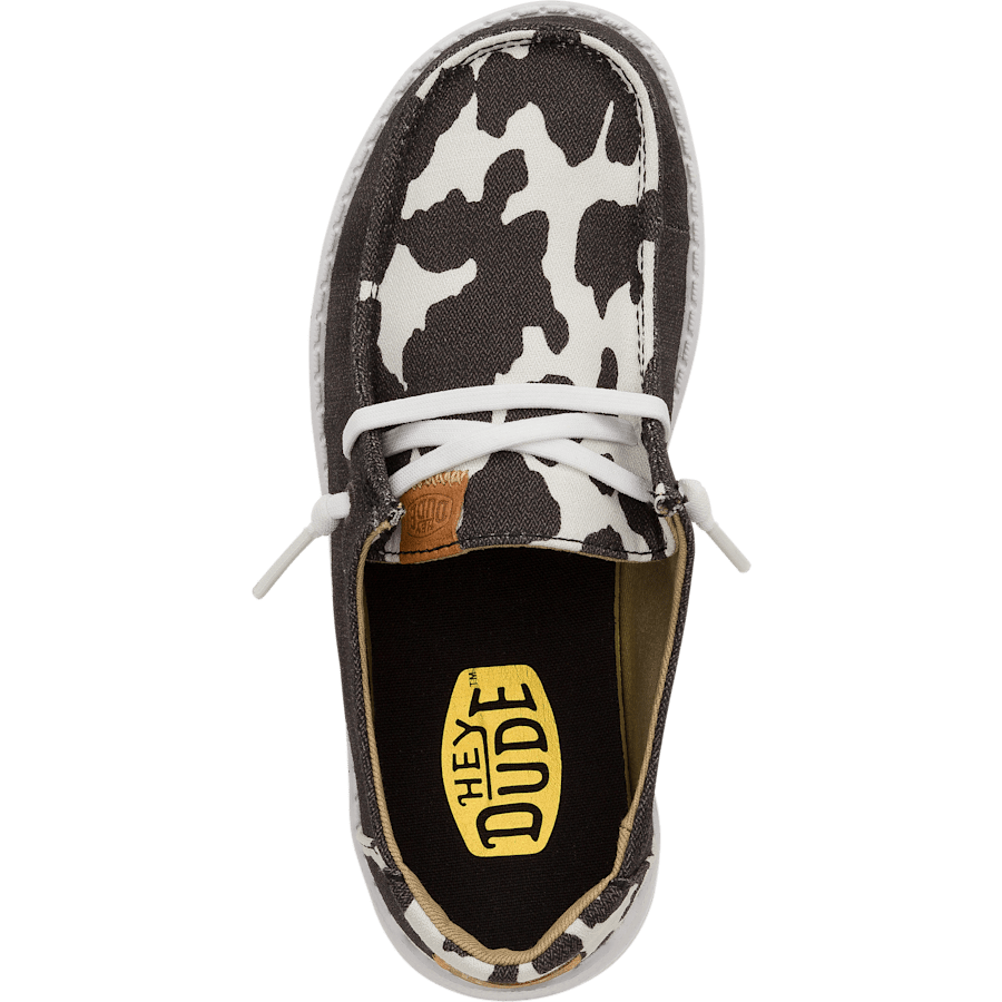 Hey Dude Girls Youth Wendy slip-on shoe with cow print canvas upper, top-down view