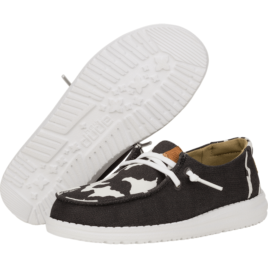 Hey Dude girls youth slip-on shoes with cow print upper and white sole shown from two angles