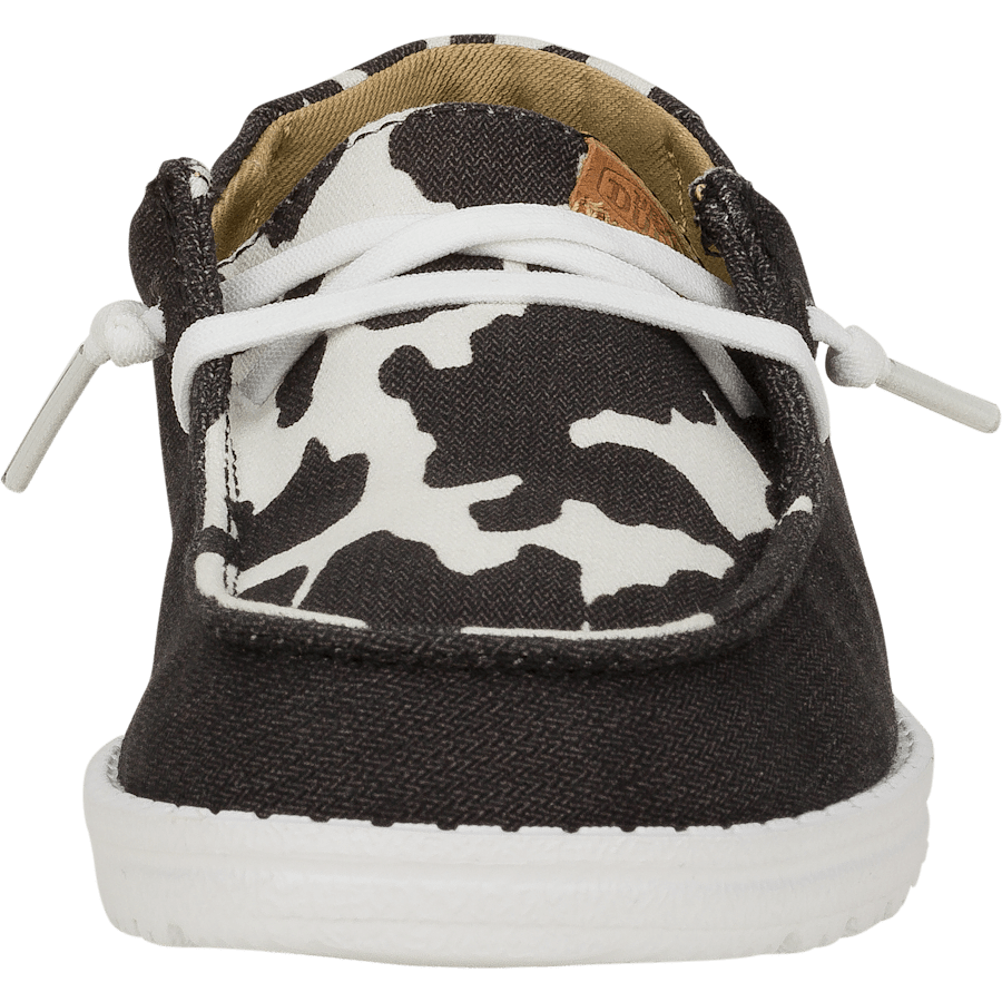 Hey Dude Girls Youth Wendy slip-on shoe front view with cow print canvas upper