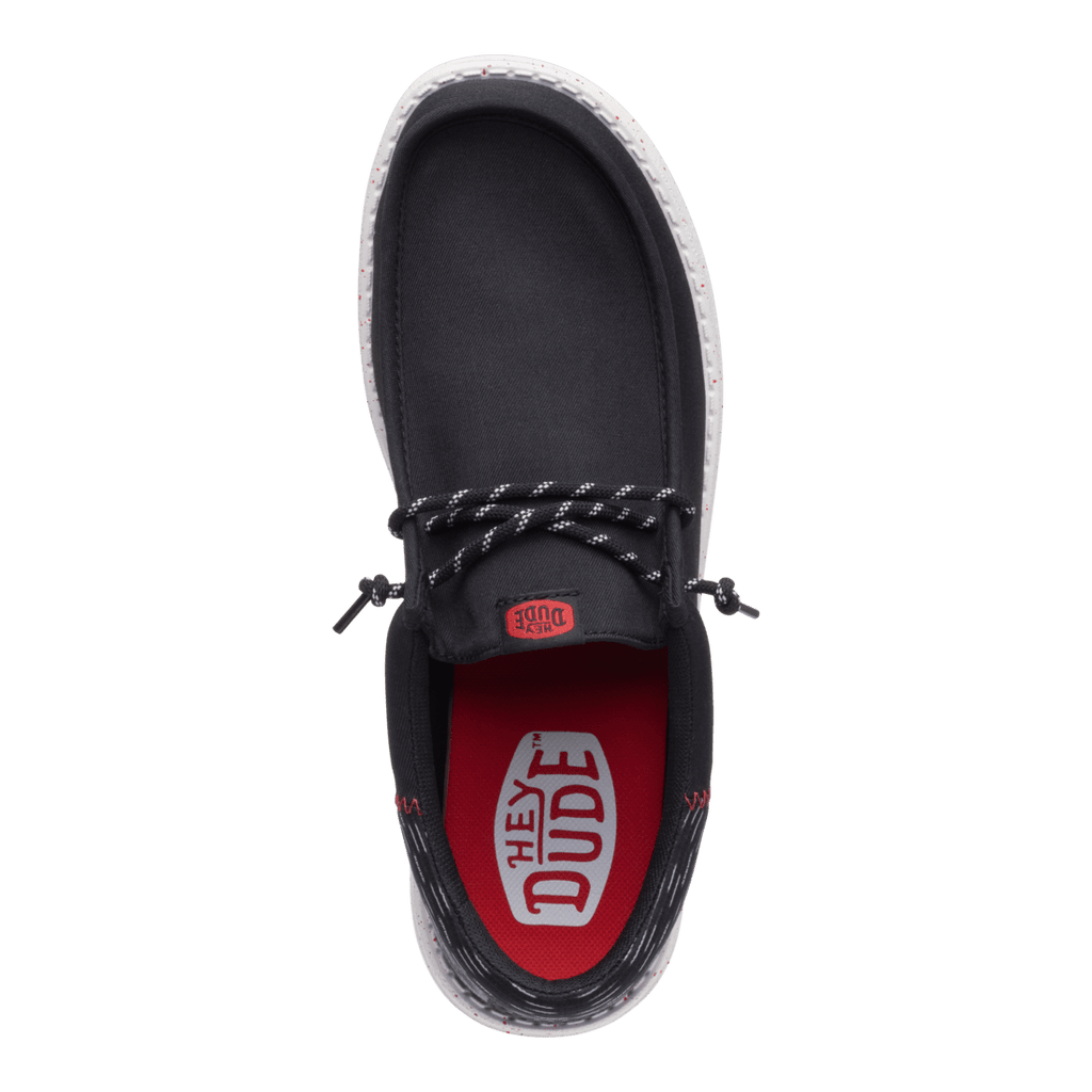 Hey Dude mens slip-on shoe with black canvas upper and red branded insole, top view
