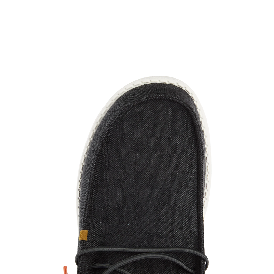 Close-up toe view of men's casual lace-up shoe with herringbone textile upper and white sole