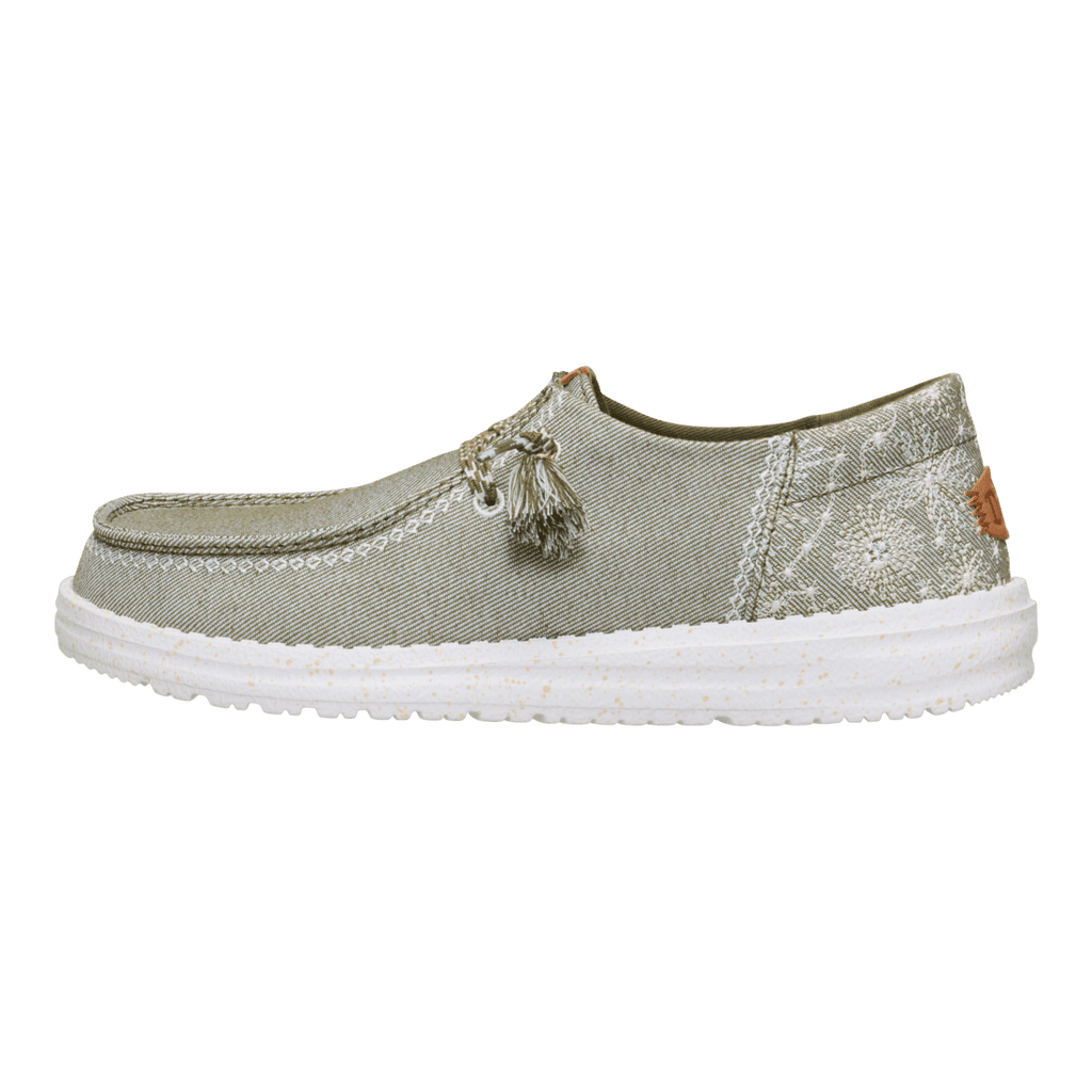 Hey Dude Wendy slip-on shoe with floral embroidery, tassel lacing, and white sole