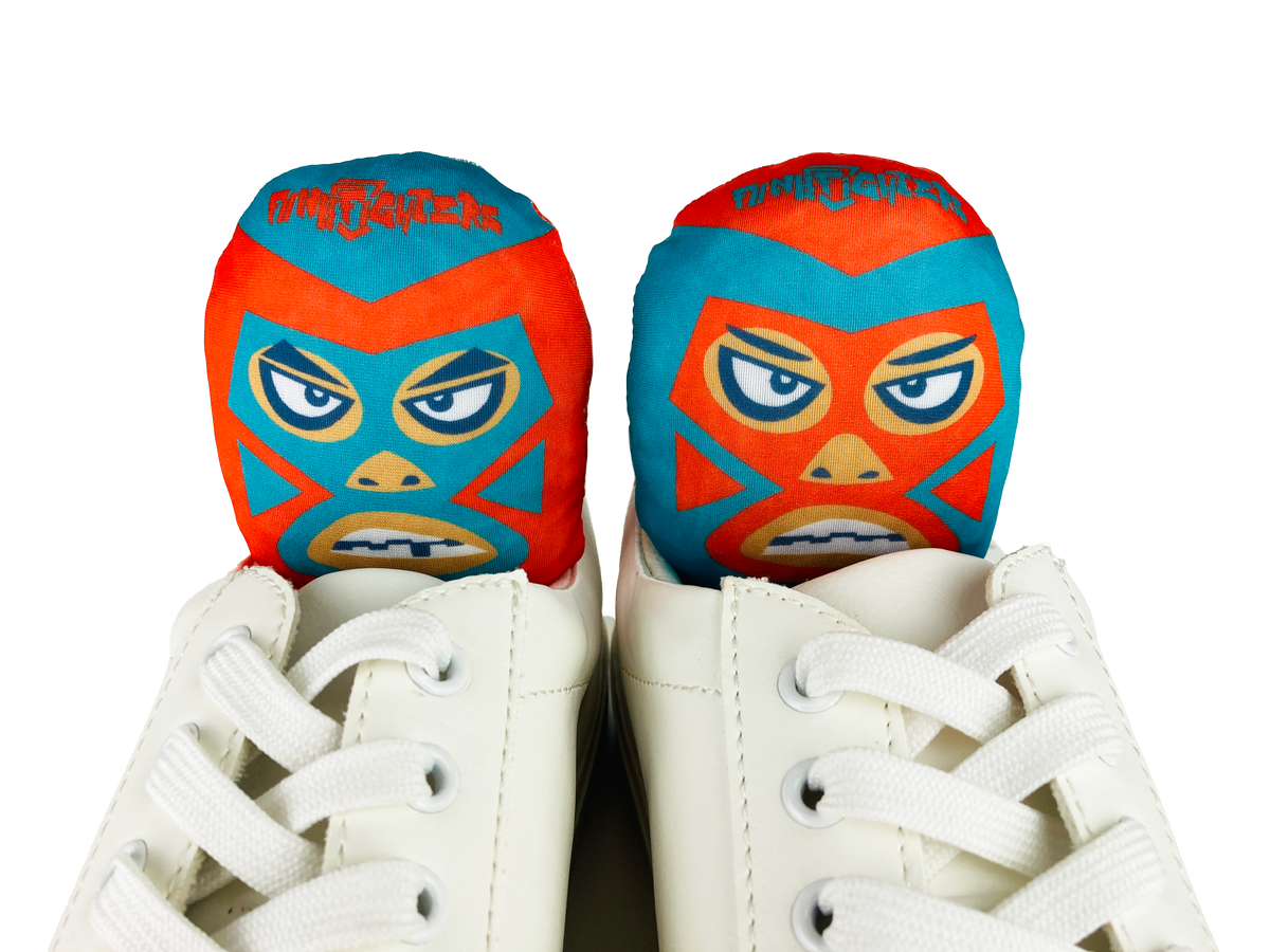 Luchador mask-designed shoe deodorizer inserts placed inside white sneakers, top view