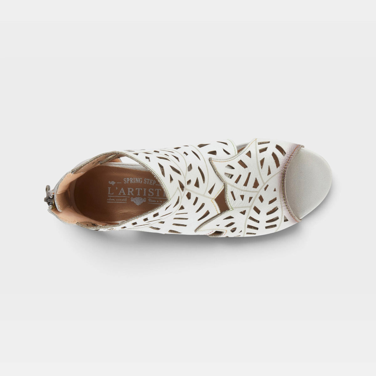 Top-down view of a laser-cut perforated leather sandal with open toe and back zipper