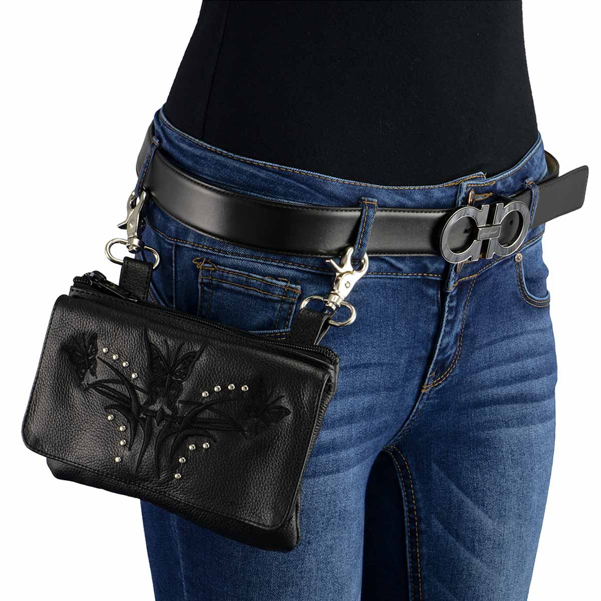 Black leather floral embossed belt pouch with silver studs clipped to denim jeans waistband