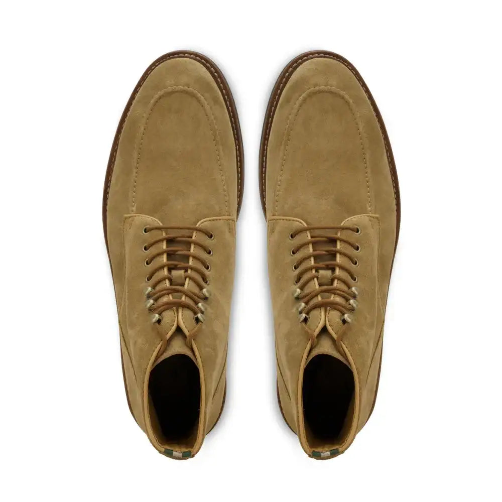 Top-down view of a pair of men's moc toe lace-up suede ankle boots on white background