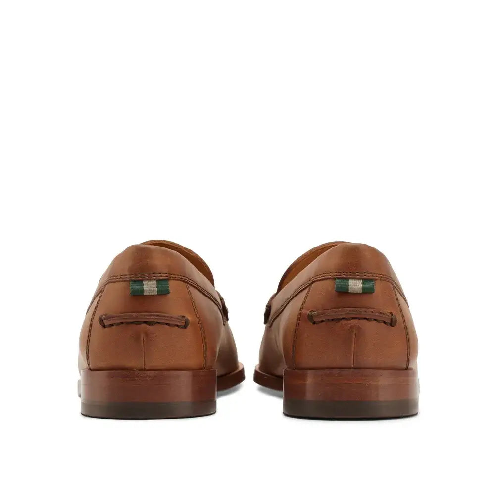 Rear view of men's tan leather penny loafers showing heel construction and branded tab detail