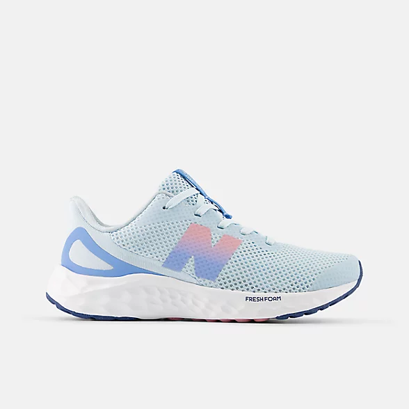 New Balance girls running shoe with light blue mesh upper and colorful gradient logo
