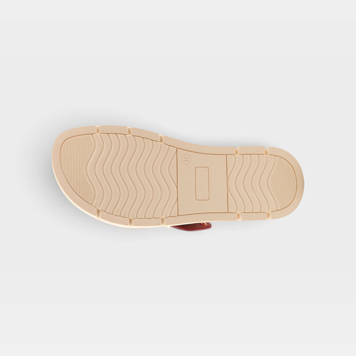 Bottom sole view of a women's slide sandal showing textured rubber outsole with wave pattern