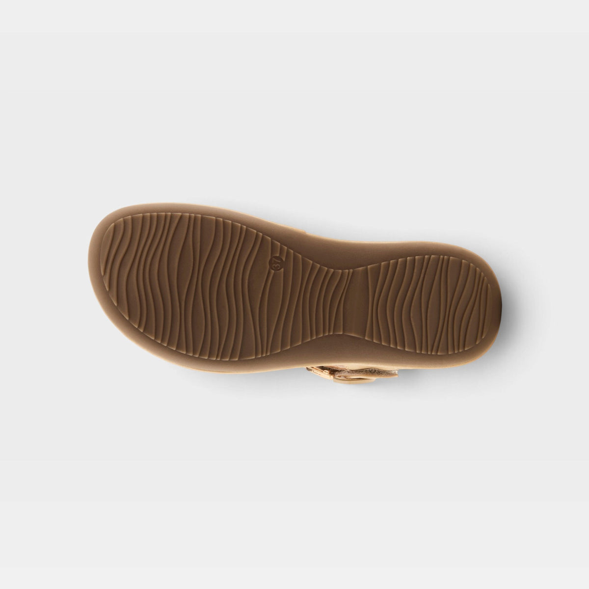 Bottom sole view of a womens sandal showing wavy rubber tread pattern and buckle strap
