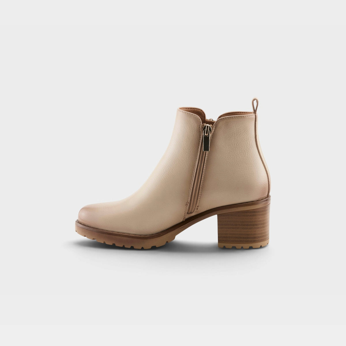 Womens ankle bootie with block heel, side zipper, and lug sole on seamless background