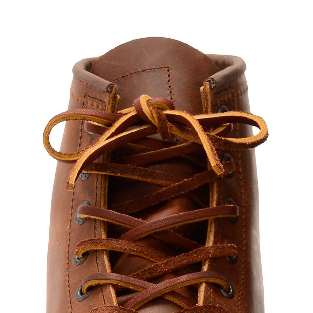 Close-up detail of leather boot laces tied at the top of a brown leather work boot