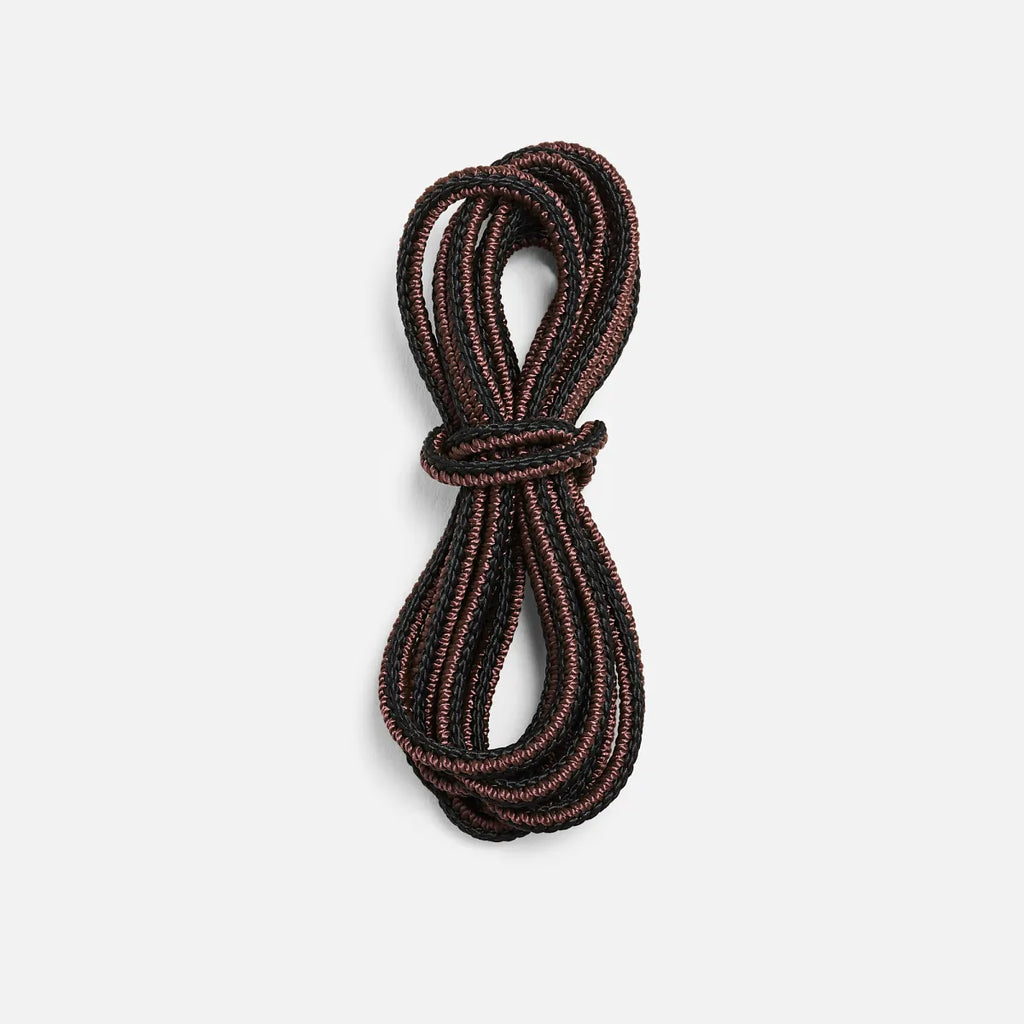 Coiled round boot laces in a braided two-tone textile, neatly bundled together