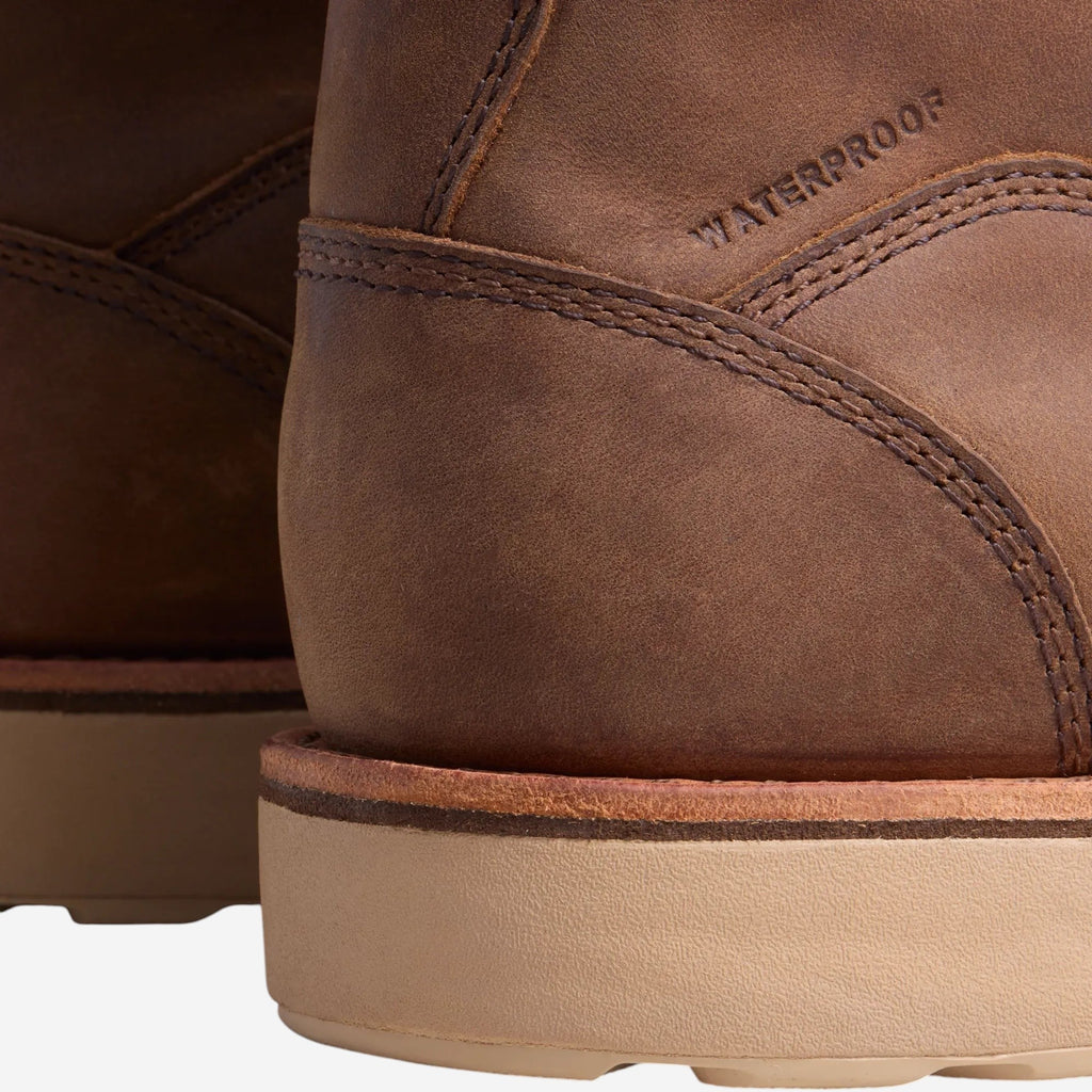 Close-up detail of waterproof tan leather boot heel with light rubber outsole and stitching
