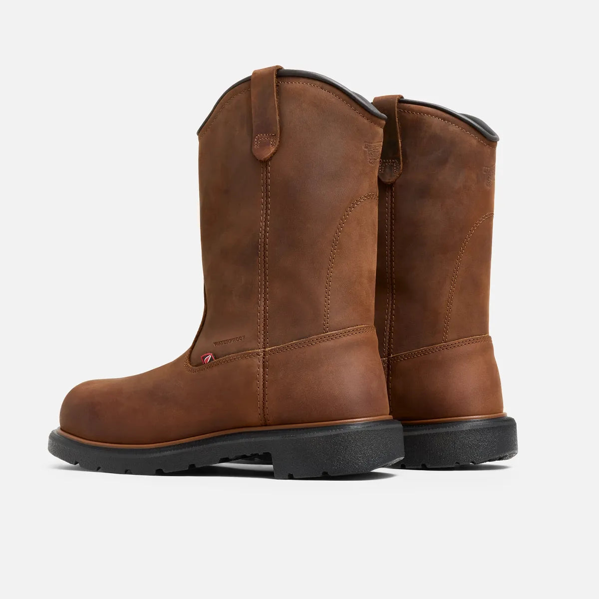 Pair of tall pull-on waterproof work boots with pull tabs and lug sole, rear three-quarter view