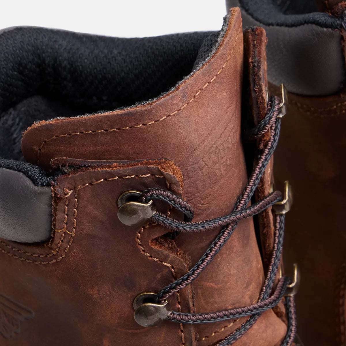 Close-up detail of Red Wing leather work boot showing laces, eyelets, and stitching