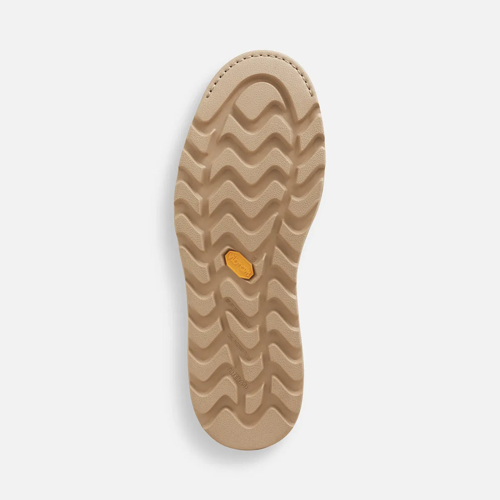 Bottom view of a Chelsea boot sole with wavy traction tread pattern and Vibram medallion