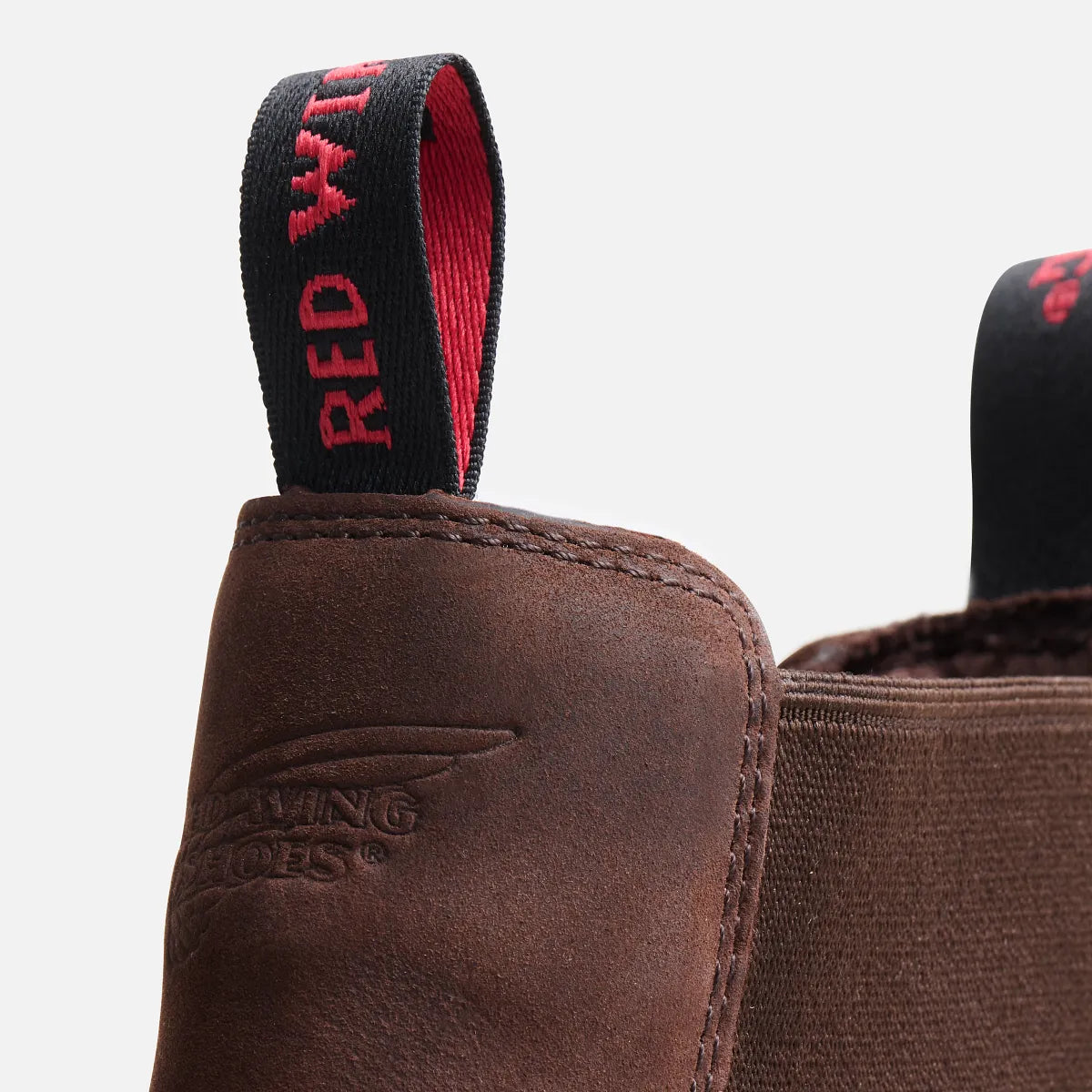 Close-up detail of Red Wing Chelsea boot pull tab and embossed logo on brown leather
