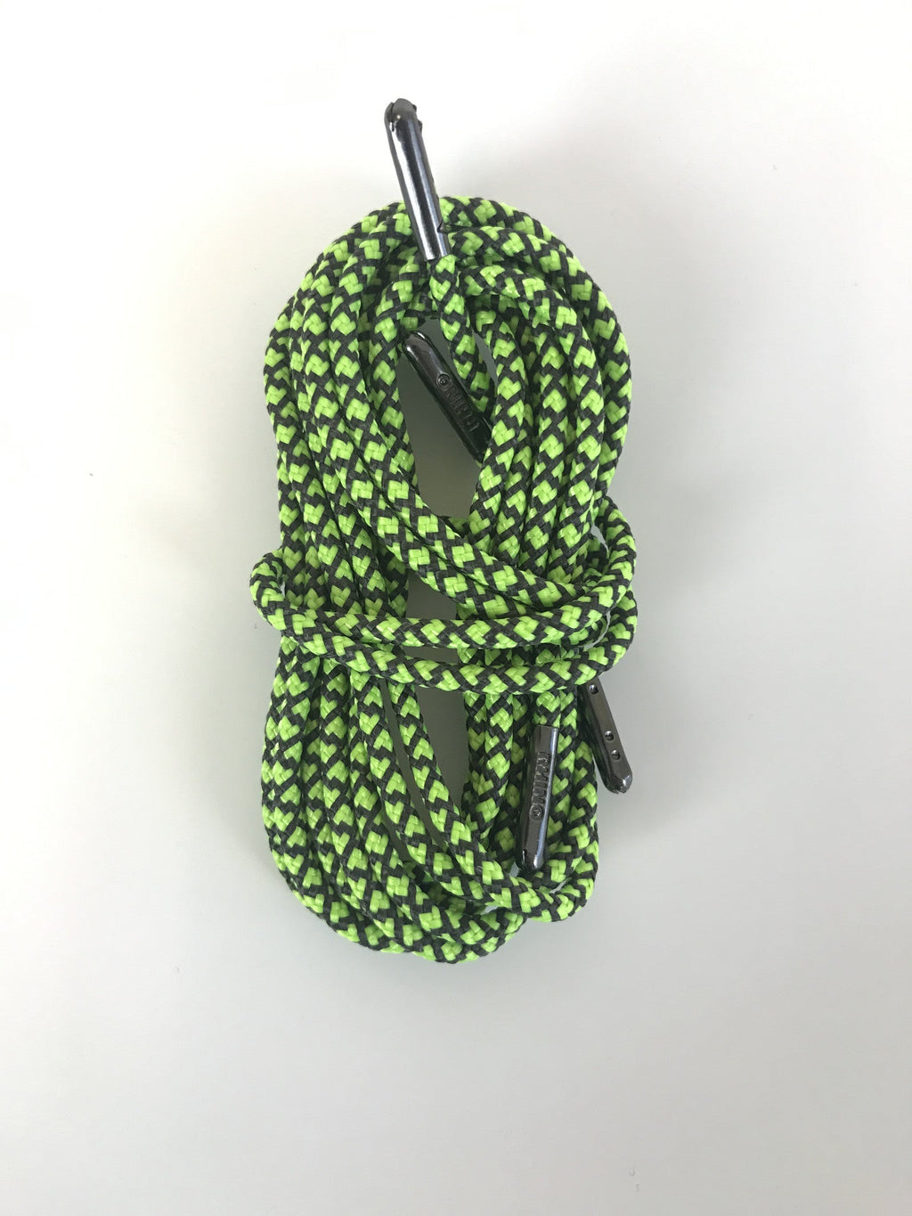 Coiled green and black patterned shoelaces with metal aglets bundled together neatly