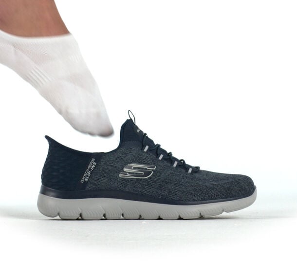 Skechers slip-in sneaker shown with a socked foot about to slide into the shoe