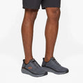 Man wearing Skechers D'Lux Walker lace-up sneakers with dark shorts, on-foot lifestyle view