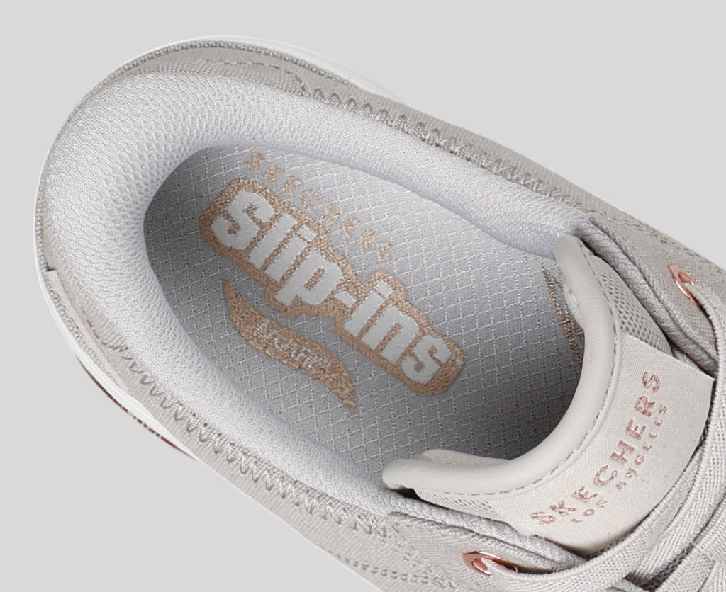 Close-up interior view of Skechers Slip-ins sneaker showing branded insole with rose gold logo