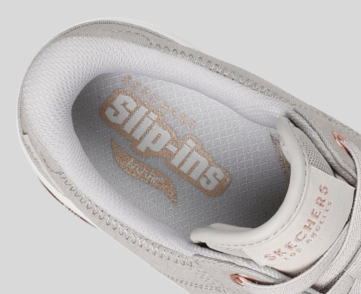 Close-up interior view of Skechers Slip-ins sneaker showing branded insole with rose gold logo