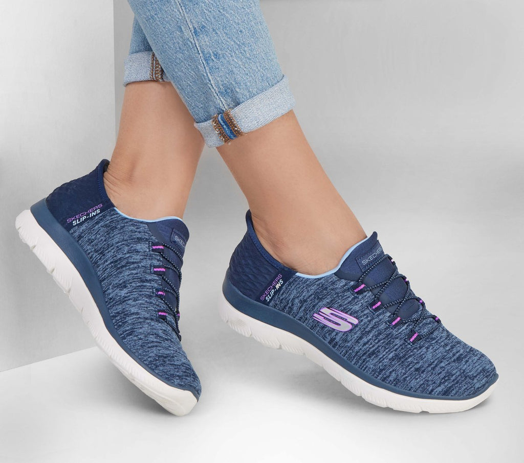 Woman wearing navy and purple Skechers Slip-Ins sneakers with white sole, paired with rolled jeans
