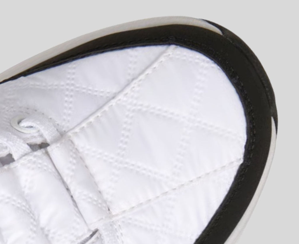 Close-up detail of white quilted sneaker toe box with black sole and trim