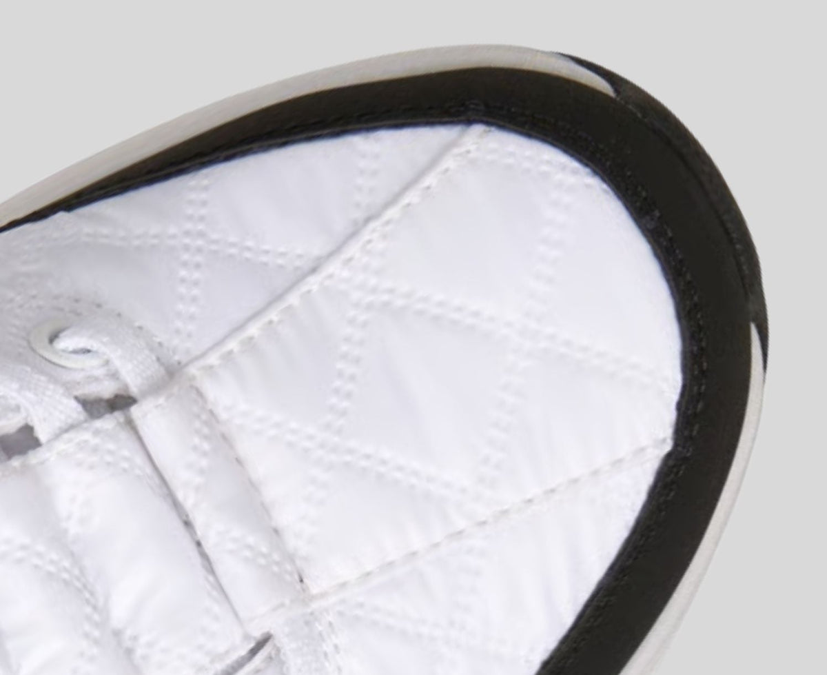 Close-up detail of white quilted sneaker toe box with black sole and trim