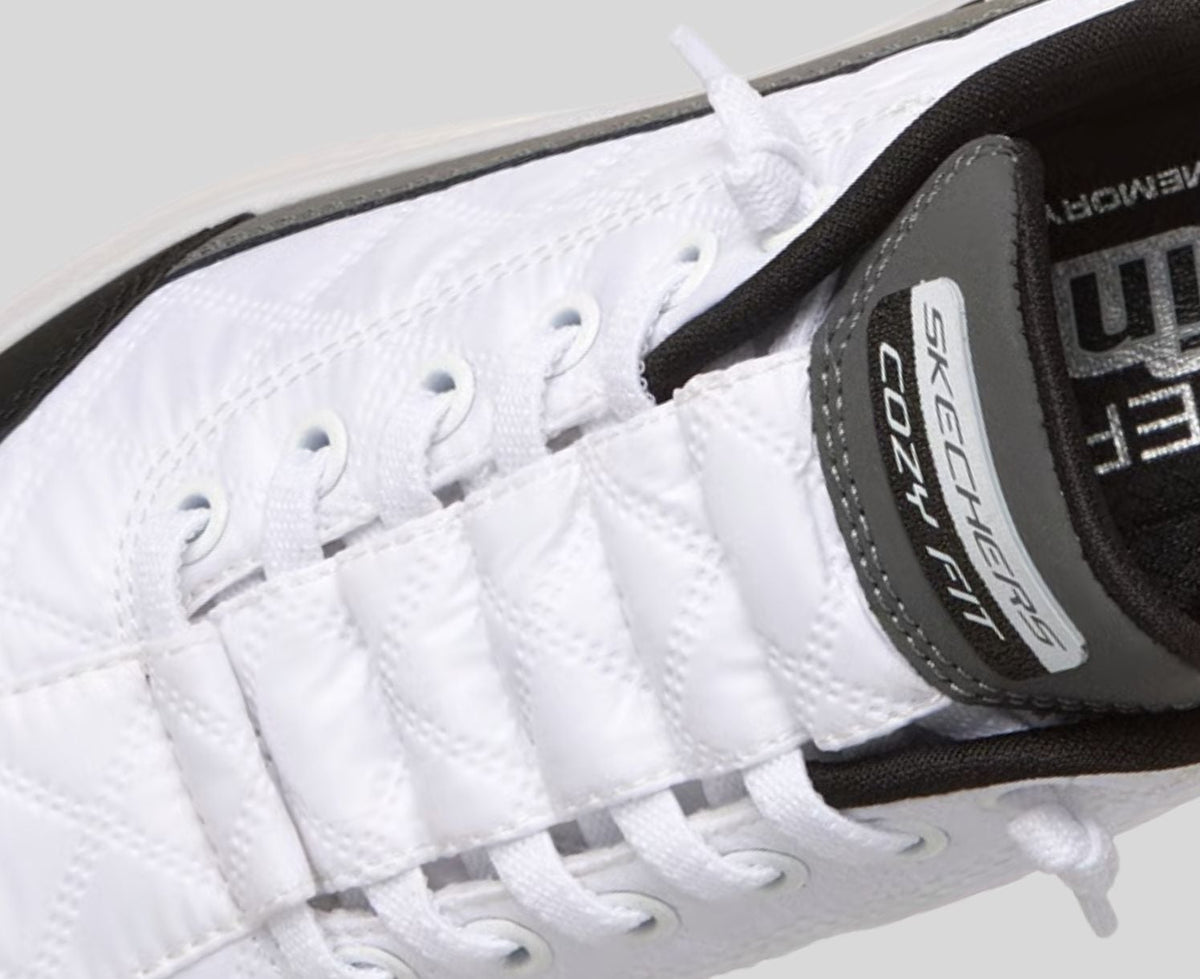 Close-up detail of Skechers Cozy Fit white sneaker tongue and lacing system