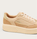 Close-up detail of Sorel platform sneaker showing suede upper, gold branding, and chunky sole