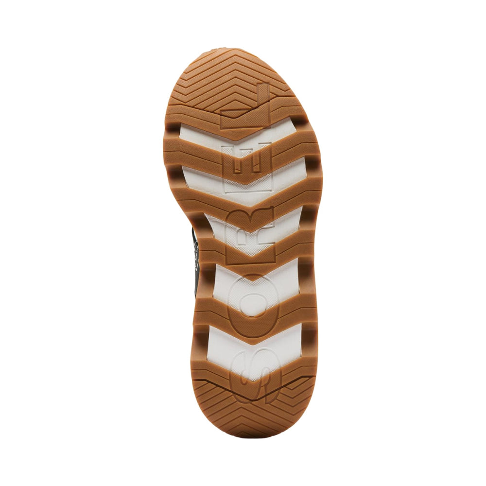 Bottom view of women's sneaker outsole showing chevron tread pattern in gum rubber