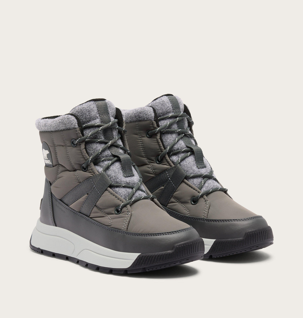 Sorel womens mid-height quilted winter boots with lace-up closure and white sole, pair shown