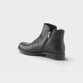 Women's leather ankle boot with side zipper closure and distressed sole, rear angle view