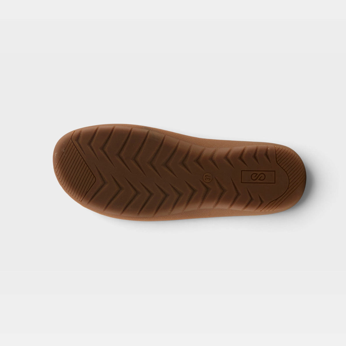 Bottom sole view of a slip-on shoe showing chevron tread pattern and brand logo