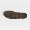 Bottom sole view of a womens leather boot with ribbed tread and heel detail