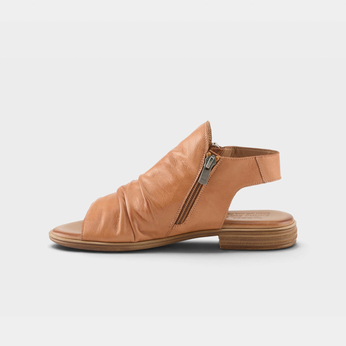 Women's flat leather sandal with ruched toe vamp, side zipper closure, and slingback strap